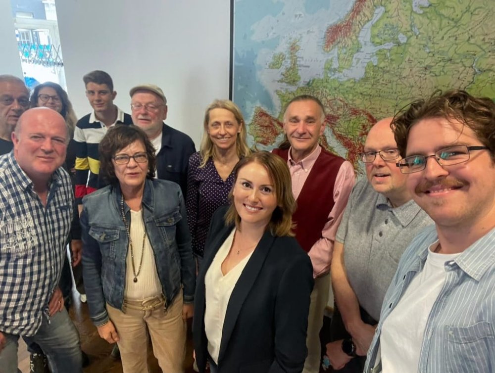 Gruppenfoto von rund zehn Teilnehmenden vor einer Europakarte