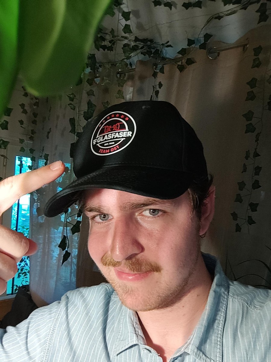 Matteo mit der schwarzen Glasfaser-Team-Ost-Cap auf dem Kopf
